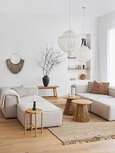 a living room with white walls and wooden flooring is furnished with natural materials such as wicker furniture