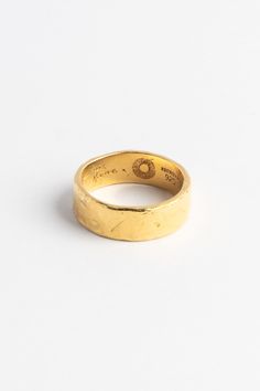 a gold wedding ring on a white background with the word love written across it in cursive writing