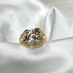 a gold ring sitting on top of a white satin fabric with the word love written in it