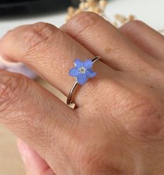 This handcrafted ring is light and comfortable on your finger and made with real pressed forget me not flower and quality uv resin. It is not tarnish and long lasting. All flowers are home grown, self dried, pressed by me in my home workshop. Forget me not flowers symbolise true love and remembrance, making them the perfect flower to give someone very special or being missed. It can be also a reminder of our loved ones that we lost. It is not only a simple and cute design but also a great keepsake gift.  They are great gift for Birthday, Wedding, Valentines Day, Mothers Day, Christmas, Bridal shower or just lift up surprise gift. ❤️Handmade in Oxfordshire, UK - Ring material: Stainless Steel - Ring wearable size: adjustable - Flower size varies: 5mm-8mm - There are slight differences betwe Dried Flowers Ring, Forget Me Not Bracelet, Adjustable Blue Flower Ring, Adjustable Blue Flower Ring For Gifting, Adjustable Blue Flower Ring Gift, Handmade Blue Flower Ring For Anniversary, Forget Me Not Earrings, Forget Me Not Necklace, Forget Me Not Jewelry