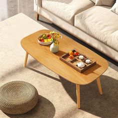 a living room with a couch, coffee table and bowl of fruit on the floor