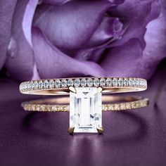 a close up of a ring on a table with purple flowers in the back ground