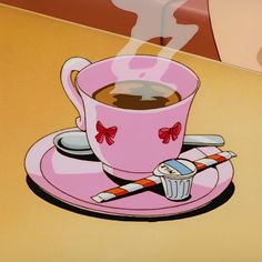 a pink coffee cup sitting on top of a saucer next to a candy cane