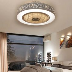 a bedroom with a large window and a round light fixture in the ceiling above it