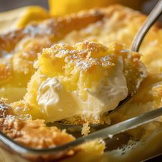 a close up of a spoon in a dish of food with lemons and powdered sugar