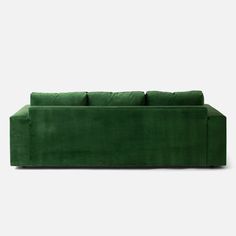 a green couch sitting on top of a white floor