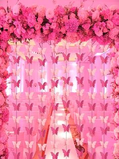 the aisle is decorated with pink flowers and butterflies