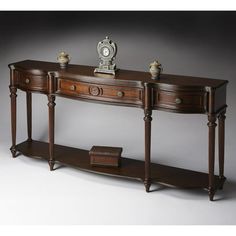 an antique console table with two drawers and a clock on it's sideboard