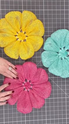 three different colored flowers sitting on top of a table