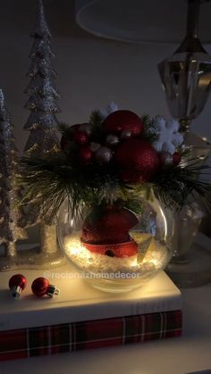 a christmas centerpiece with ornaments and lights in a bowl on top of a table