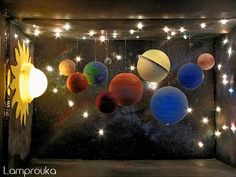 the solar system is hanging from strings in front of a window with stars on it