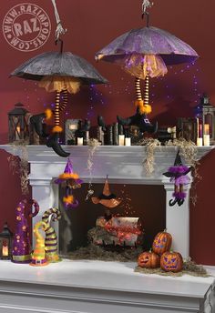 a fireplace with halloween decorations and umbrellas on it's mantel above the fire place