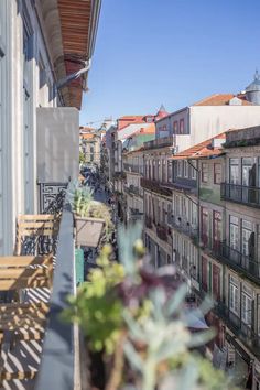 a balcony with tables and chairs on it next to the building's balconies