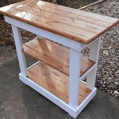 a white and wood table sitting on top of a sidewalk