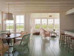 a dining room table and chairs in front of a bar with stools next to it