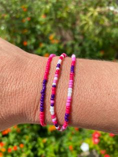 Layer up these three fun bracelets. Each is a different pattern. Colors are magenta, pink, purple and white. Made with a stretchy band for easy use. Purple Beaded Bracelets With Colorful Beads For Summer, Colorful Beaded Purple Bracelets For Summer, Purple Colorful Beaded Bracelets For Summer, Trendy Pink Beaded Wrap Bracelet, Pink Hypoallergenic Beaded Bracelets For Beach, Hypoallergenic Pink Beaded Bracelets For Beach, Pink Wrap Bracelet With Round Beads, Purple Friendship Bracelets For Summer, Flexible Pink Beaded Bracelets