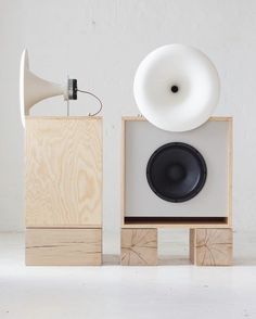 two speakers and a speaker on wooden blocks in front of a wall with a white background