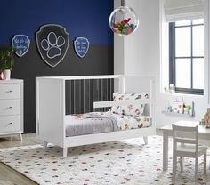 a child's bedroom with white furniture and blue walls