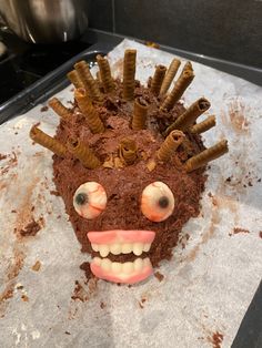 a cake that has been made to look like a head with worms coming out of it