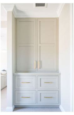 an empty room with white cabinets and drawers