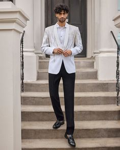 This tuxedo set features intricate silver and gold embroidery in a linear waterfall pattern. The ivory jacket has a single - buttoned shawl satin lapel. The crisp white pin tucked shirt shows black porcelian buttons. It comes with contrasting black straight pants.From Seema Gujral's For the love of London collection. DELIVERY TIMEPlease allow 8-12 weeks for your outfit to arrive. FABRIC DETAILSNet Professional cleaning only. Black Straight Pants, Ivory Tuxedo, Indian Wedding Clothes For Men, White Tuxedo, White Pin, Wedding Clothes, Gold Embroidery, 12 Weeks, Professional Cleaning