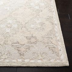 a large white rug on top of a wooden floor