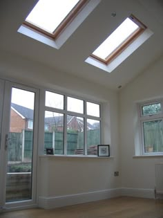 an empty room with two skylights in it