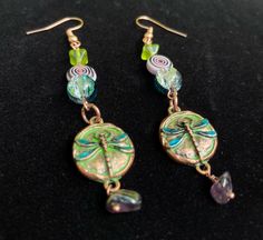 the earrings are decorated with green and blue beads