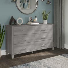 a gray dresser sitting in front of a blue wall