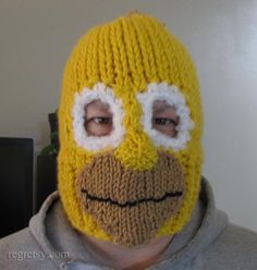 a man wearing a knitted yellow mask with white eyes