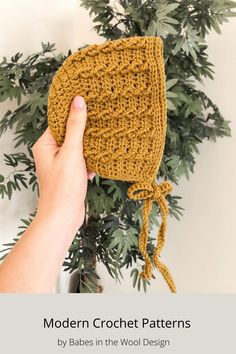 a hand holding a crochet bag next to a potted plant with the words modern crochet patterns written on it