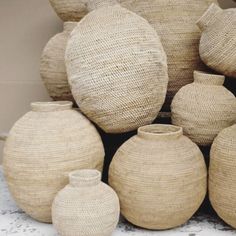 a pile of woven vases sitting next to each other on top of a table