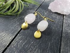 These boho dangle earrings feature 14mm x 10mm rose quartz nuggets with small 8mm x 10mm gold-plated oval charms dangling from the bottom. Rose Quartz is known as the stone of universal love, and is said to restore trust and harmony in relationships and encourage unconditional love. Rose Quartz purifies and opens the heart at all levels to promote love, self-love, friendship, deep inner healing, and feelings of peace. These lightweight earrings measure approximately 1 7/8 inches from the top of Nickel-free Rose Quartz Dangle Earrings, Rose Quartz Gemstone Dangle Earrings, Rose Quartz Drop Earrings For Jewelry Making, Pink Quartz Jewelry, Nugget Earrings, Geometric Rose, Rose Quartz Jewelry, Rose Gold Quartz, Rose Quartz Earrings