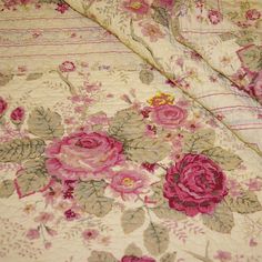 an old fashioned quilt with pink flowers on it