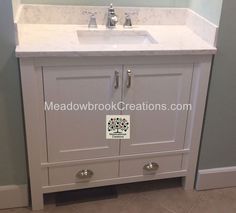 a white bathroom sink sitting under a mirror