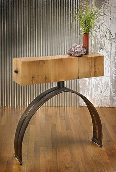 a wooden table with metal legs and a potted plant sitting on top of it