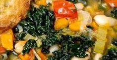 a bowl filled with vegetables and bread on top of a table