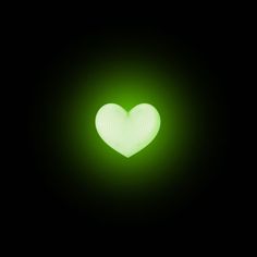 a green heart in the dark with light coming from it's center and back