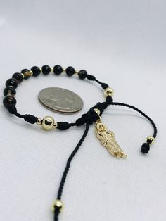 "Handmade St. Judas Thaddeus bracelet with natural nazar boncuk stone beads known as Turkish eye for protection and evil eye. 10 nazar boncuk beads as Ave Maria for a rosary, 2 mistery and plated gold beads as Our Father. Adjustable from 7''inches up to 9''inches. Material: Natural Agate stone beads Black/Brown 6mm Plated gold beads 6mm, 4mm, 3mm St. Judas Thaddeus pendant 2.50cm Black string #9 Pulsera de San Judas Tadeo hecha a mano con bolas de piedra natural nazar boncuk conocido como el ojo Gold Hand-strung Rosary Bracelet For Healing, Spiritual Rosary Bracelet With Gold Beads As Gift, Spiritual Gold Beads Rosary Bracelet Gift, Spiritual Gold Beads Bracelets, Adjustable Spiritual Rosary Bracelet With Polished Beads, Gold Rosary Bracelet For Healing, Gold Beaded Rosary Bracelet For Healing, Adjustable Rosary Bracelet With Black Beads For Gift, Adjustable Black Beads Rosary Bracelet As A Gift