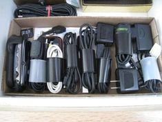 a box filled with different types of electronic devices and cords on top of each other