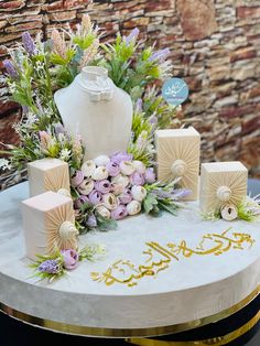 there is a cake with flowers and candles on the table in front of a brick wall