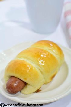 a hot dog wrapped in bread on a plate