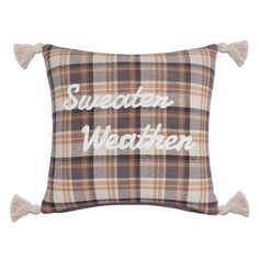 a brown and white plaid pillow with the words sweden written on it