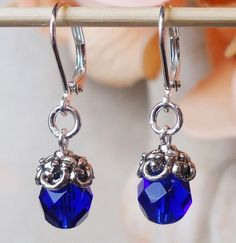 This lovely pair of earrings features a luminous bevel-cut cobalt blue Austrian crystal, which are accented with an ornate pewter bead cap, plated in sterling silver. Hanging from a surgical steel lever-back, it measures 1.25 " in length.     These stunning small dangle earrings are unique, feminine and eye-catching, a great accent to any wardrobe. Available in 24 karat gold plate. Available with clip-on earrings top, please see last photo. Patina Jewelry, Wood Hoop Earrings, Galaxy Earrings, Gold Filigree Earrings, Small Dangle Earrings, Mystic Topaz Earrings, Cobalt Blue Earrings, Blue Dangle Earrings, Spike Earrings