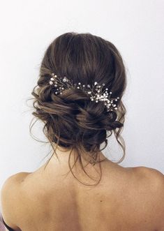 a woman with her back to the camera wearing a hair comb and flowers in her hair