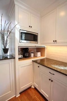 a kitchen with white cabinets and granite counter tops, along with a black stove top oven