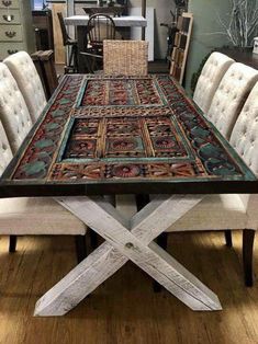 a dining room table with chairs and a rug on the top that looks like an x