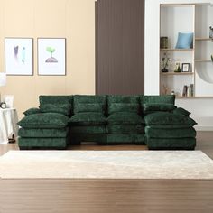 a large green couch sitting on top of a wooden floor next to a white rug