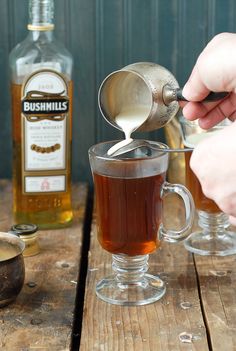 a person pours tea into a glass mug