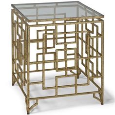 a gold metal and glass side table with geometric designs on the top, against a white background